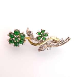 Natural Burmese jadeite floral brooch with vivid green cabochons and pavé diamond leaves in gold and silver alloy, photographed in studio lighting for GalaxyGems NYC — a refined piece symbolizing prosperity and timeless Myanmar artistry.