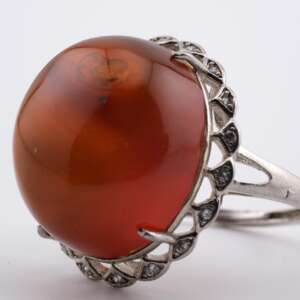 Side angle of 100-million-year-old Burmite amber cabochon ring showing high dome and silver prong structure