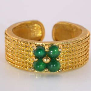 Close-up front view of a gold-tone adjustable ring featuring four small round green jadeite cabochon stones set in a clover pattern on a textured gold tone alloy band.