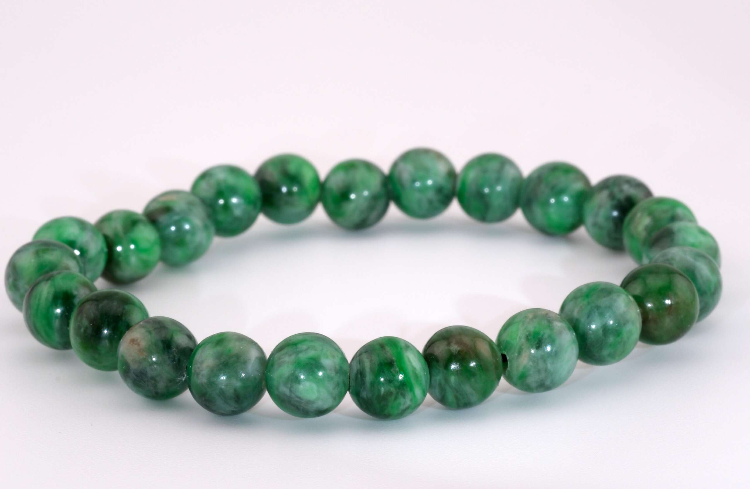 A polished beaded bracelet made of natural Maw Sit Sit jadeite, with approximately 8.5mm round beads showing mottled dark and light green patterns, displayed on a white background.