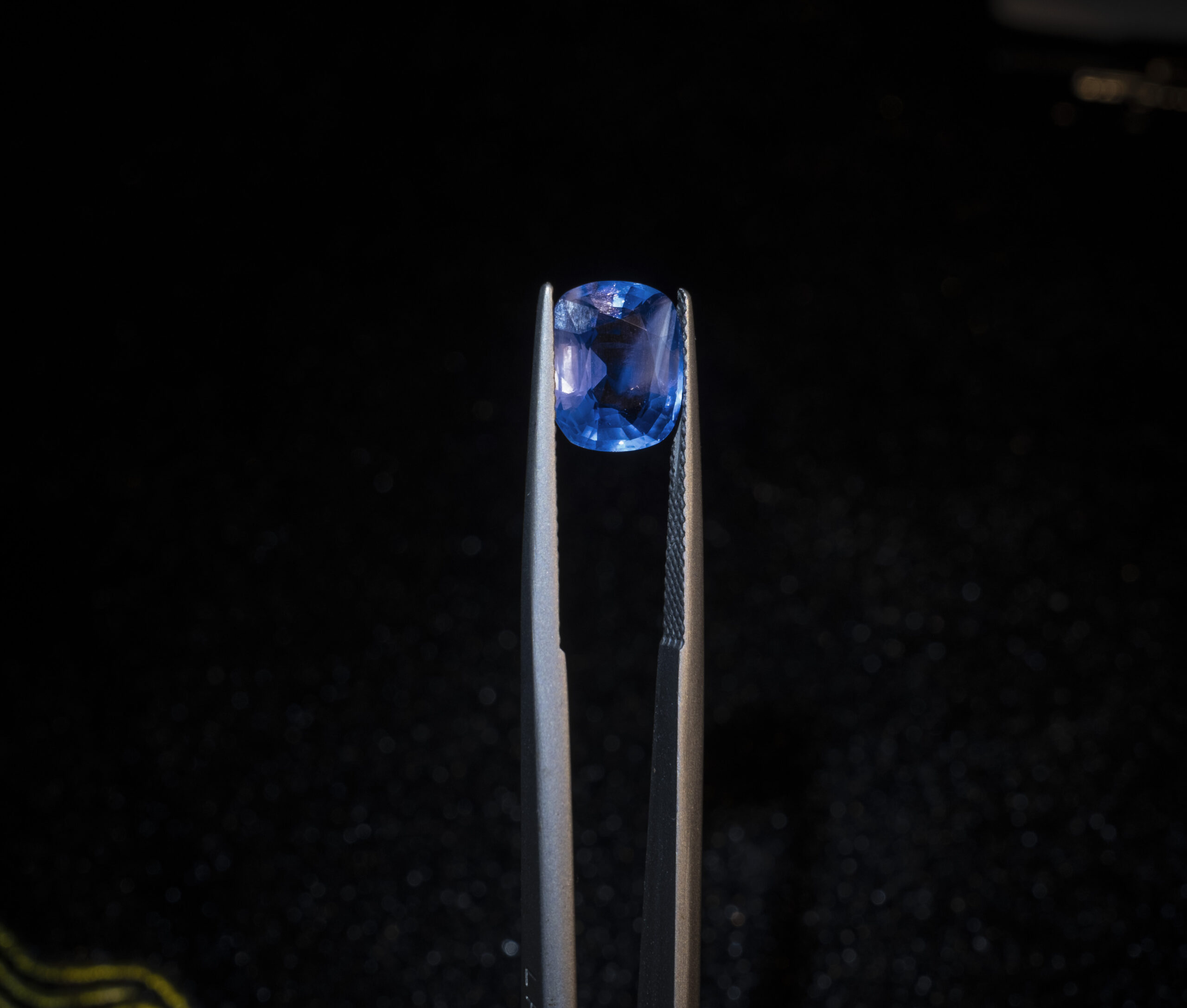 3.61-carat unheated Ceylon sapphire held in gem tweezers on black background – GalaxyGems